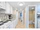 Bright kitchen with white cabinetry, granite countertops, and open access to other rooms at 2001 S Ocean Blvd. # 1303, Myrtle Beach, SC 29577