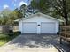 Double garage with white painted doors, surrounded by a fenced-in yard, and concrete driveway at 2005 Loblolly St., Georgetown, SC 29440