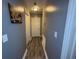 Long hallway featuring neutral walls, a grey door, wood-look tile floors, and incandescent lighting at 2005 Loblolly St., Georgetown, SC 29440