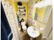Bathroom with yellow walls, floral shower curtain, sink, and wall storage at 202 28Th Ave. N # 5, North Myrtle Beach, SC 29582