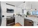 Bright kitchen featuring stainless steel appliances, white cabinetry, quartz countertops, and adjacent living space at 208 Ocean Blvd. N # 228, North Myrtle Beach, SC 29582