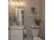 Well-lit, stylish bathroom with brushed nickel fixtures, white cabinets, and decorative wall art at 220 Gloucester Way, Little River, SC 29566