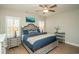 Cozy bedroom features a ceiling fan, neutral walls, and a wooden floor with blue quilt bedding and shuttered windows at 220 Gloucester Way, Little River, SC 29566