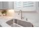 Well-lit kitchen with stainless steel sink, white subway tile backsplash and marble counter tops at 220 Gloucester Way, Little River, SC 29566