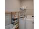 Bright laundry room with modern washer and dryer, storage shelving, and convenient laundry basket at 220 Gloucester Way, Little River, SC 29566