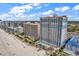 Aerial view of condo buildings, beach, and pool with lounge chairs at 2201 S Ocean Blvd. # 707, Myrtle Beach, SC 29577