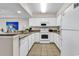 Bright kitchen featuring white cabinets, tile flooring, granite countertops, and modern appliances at 2201 S Ocean Blvd. # 707, Myrtle Beach, SC 29577