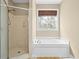 Bright bathroom features a jetted tub and a walk-in shower with neutral tile and bronze hardware at 2213 Gazebo Ct., North Myrtle Beach, SC 29582
