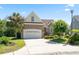 Attractive two-story home featuring a brick facade, lush landscaping, and a two-car garage on a sunny day at 2213 Gazebo Ct., North Myrtle Beach, SC 29582