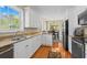 Well-lit kitchen with white cabinets, stainless steel appliances, and a view into the dining area at 2213 Gazebo Ct., North Myrtle Beach, SC 29582