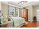 Comfortable main bedroom with natural light, wood floors, and decorative armoire at 2213 Gazebo Ct., North Myrtle Beach, SC 29582