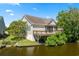 Rear exterior view of home featuring canal front yard, wooden deck, and screened porch at 2213 Gazebo Ct., North Myrtle Beach, SC 29582
