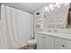 Bright bathroom featuring white vanity, shelving, and a shower with textured white curtain at 223 Maison Dr. # F-12, Myrtle Beach, SC 29572