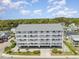 Expansive aerial shot showcasing a multi-story condo with balconies surrounded by lush greenery and parking at 2406 S Ocean Blvd. # 301, North Myrtle Beach, SC 29582