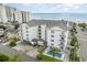 Aerial view of a bright white condo building with beach in the background and a pool at 2406 S Ocean Blvd. # 301, North Myrtle Beach, SC 29582