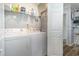 Laundry room with washer, dryer, storage shelf, and white door at 2406 S Ocean Blvd. # 301, North Myrtle Beach, SC 29582