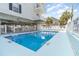 Sparkling outdoor pool featuring lounge chairs, palm trees, and a fenced perimeter for relaxation at 2406 S Ocean Blvd. # 301, North Myrtle Beach, SC 29582