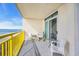 Relaxing ocean view balcony featuring a sliding door, chairs, and bright yellow metal railing at 2711 Ocean Blvd. S # 915, North Myrtle Beach, SC 29582