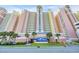 Multi-story beachfront resort with pale pink siding, multiple balconies and mature palm trees in manicured landscaping at 2711 Ocean Blvd. S # 915, North Myrtle Beach, SC 29582