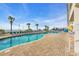 Outdoor pool surrounded by blue lounge chairs and palm trees at 2711 Ocean Blvd. S # 915, North Myrtle Beach, SC 29582