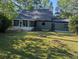 Expansive backyard featuring a fire pit, a screened porch, and lush greenery at 302 St. Andrews Ln., Myrtle Beach, SC 29588