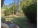 Lush backyard featuring a fire pit, mature trees, and a storage shed at 302 St. Andrews Ln., Myrtle Beach, SC 29588