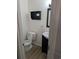 Bathroom featuring toilet, sink with vanity, stylish mirror, and a small wall shelf at 302 St. Andrews Ln., Myrtle Beach, SC 29588