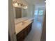 Bright bathroom featuring a wood vanity, a large mirror, a window, and a shower-tub combo at 302 St. Andrews Ln., Myrtle Beach, SC 29588