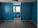Spacious bedroom with blue walls, carpeted floors and natural light streaming through a window with a built-in bench at 302 St. Andrews Ln., Myrtle Beach, SC 29588