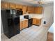 Kitchen features a black refrigerator, oak cabinets, tile flooring and a ceiling fan at 302 St. Andrews Ln., Myrtle Beach, SC 29588