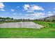 Community pond view with fountain, lush green grass, and waterfront homes on a beautiful day at 3034 Viceroy Loop, Little River, SC 29566