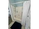 Enclosed shower and tub with white tile and fixtures in a blue-walled bathroom at 308 44Th Ave. N, North Myrtle Beach, SC 29582