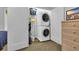 Convenient laundry closet equipped with a stacked washer and dryer, and shelving for supplies at 308 44Th Ave. N, North Myrtle Beach, SC 29582