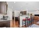 Open-concept kitchen with bar seating, dark cabinets, granite countertops, and seamless flow to living area at 3212 Saddlewood Circle, Myrtle Beach, SC 29579
