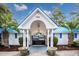Community building featuring a white facade, blue roof, palm trees, and gated entry for residents only at 3563 Chestnut Dr. # 3563, Myrtle Beach, SC 29577