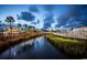 Scenic waterfront view with amusement park rides, lush greenery, and a tranquil river under a cloudy sky at 3563 Chestnut Dr. # 3563, Myrtle Beach, SC 29577