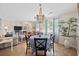 Open-concept dining area with view to the living room, featuring a chandelier and large windows at 3731 Spruce Dr., Myrtle Beach, SC 29577