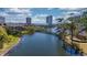 Scenic aerial view of a lake community, featuring a charming bridge and waterfront buildings under a blue sky at 410 Melrose Pl. # 110, Myrtle Beach, SC 29572
