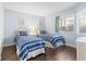 Twin bedroom with striped bedding, neutral walls, and wood-look floors at 410 Melrose Pl. # 110, Myrtle Beach, SC 29572