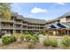 Exterior view of the building showcasing multiple levels with covered walkways and lush landscaping at 410 Melrose Pl. # 110, Myrtle Beach, SC 29572