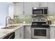 Kitchen with stainless steel appliances, mosaic backsplash, and light-colored cabinets at 410 Melrose Pl. # 110, Myrtle Beach, SC 29572