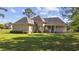 Side view of a brick home with a well-manicured lawn and cozy porch, nestled in a peaceful setting at 4100 Hagwood Circle, Conway, SC 29526