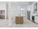 Open concept kitchen with island, white cabinets, stainless appliances, and light wood flooring at 4100 Hagwood Circle, Conway, SC 29526