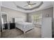 This bedroom features a tray ceiling with fan, a window with natural light and neutral colors at 411 Mahogany Dr. # 202, Murrells Inlet, SC 29576