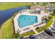 Aerial view of a large community pool with lounge chairs, tables and a clubhouse, and people enjoying the sun and water at 411 Mahogany Dr. # 202, Murrells Inlet, SC 29576