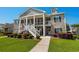 Exterior view of a two story building with inviting front porch and manicured landscaping at 411 Mahogany Dr. # 202, Murrells Inlet, SC 29576