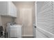 Bright laundry room with white washer and dryer appliances and built in storage cabinets at 411 Mahogany Dr. # 202, Murrells Inlet, SC 29576