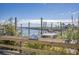 Picturesque waterfront view from a wooden boardwalk with boats, pylons, a quaint harbor, and local plant life at 411 Mahogany Dr. # 202, Murrells Inlet, SC 29576