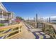 Wooden boardwalk with decorative railings looking out towards the marina with local flags, boats, and a beautiful view at 411 Mahogany Dr. # 202, Murrells Inlet, SC 29576