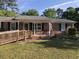 Charming single-story brick home with a front yard, ramp, and cozy porch seating at 4204 Peachtree Ln., Myrtle Beach, SC 29588